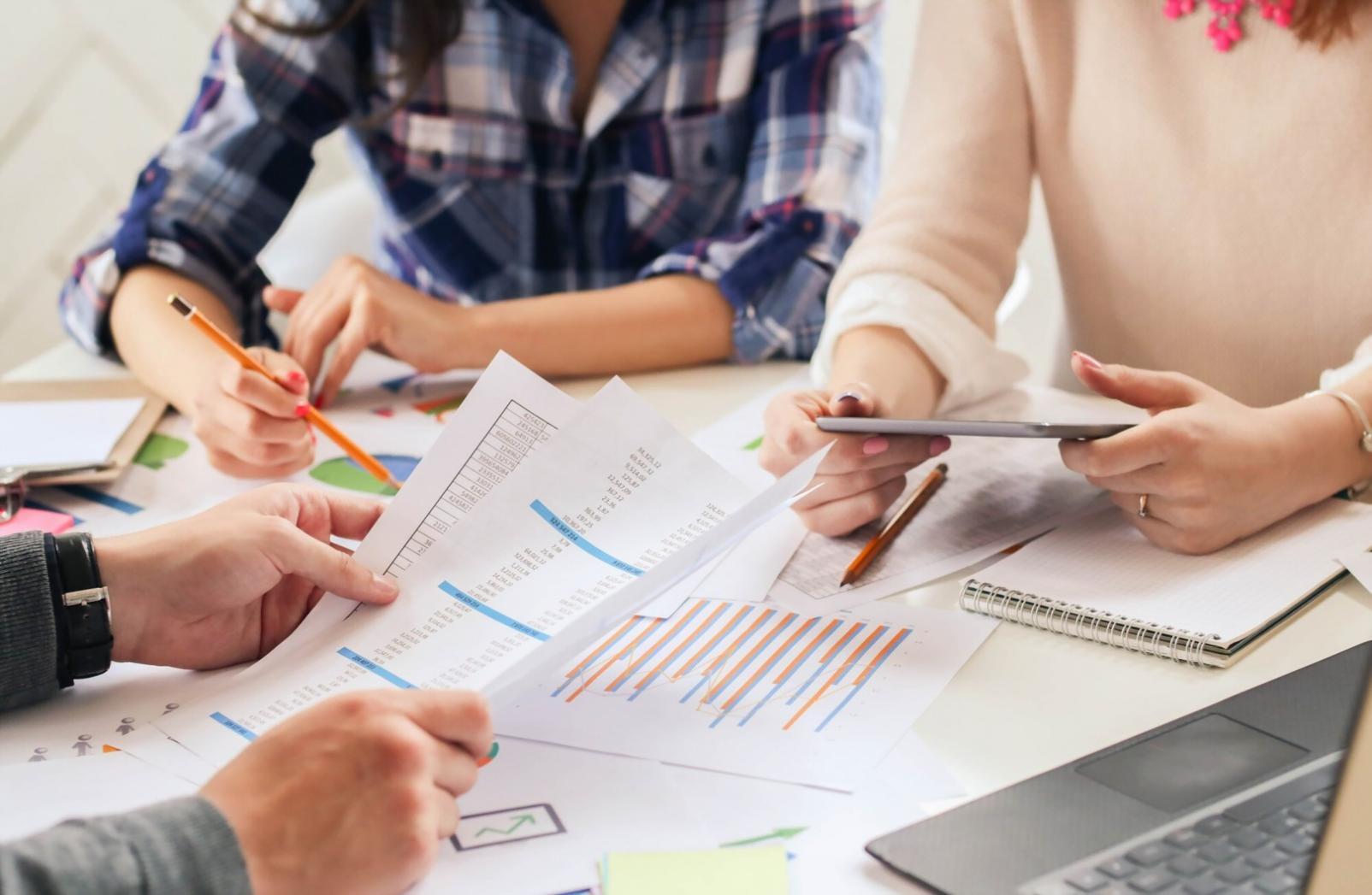Business team collaborating over financial reports and planning documents on conference table